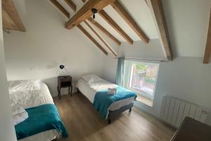 1 dormitorio con 2 camas y ventana en Gîte dans les Vosges Gite du Feing des Loges, en Vagney