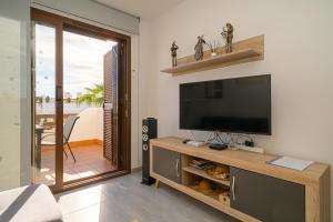 a living room with a flat screen tv on a entertainment center at Casa Musica in San Juan de los Terreros