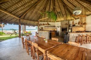 a dining room with a table and a kitchen at Rancho Noé Cumbuco in Cumbuco