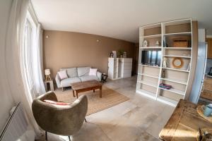 een woonkamer met een bank en een stoel bij Les 3 Monts - vue panoramique sur les montagnes in Annecy