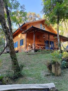 a large wooden house in the woods at Chalé Morada Alma Gêmea in Campo Alegre