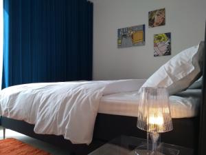 um quarto com uma cama com lençóis brancos e uma mesa de vidro em ROOFTOP em Oostende