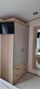 a bedroom with a large cabinet and a mirror at Littlesea-wv55 Weymouth in Wyke Regis