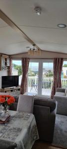 a living room with a couch and a table at Littlesea-wv55 Weymouth in Wyke Regis