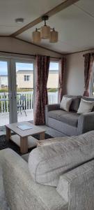 a living room with two couches and a table at Littlesea-wv55 Weymouth in Wyke Regis