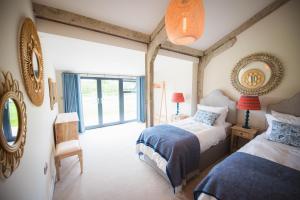 a bedroom with two beds and a window at Holly Lodge and Little Orchard in Kingsdown