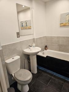 uma casa de banho com um WC, um lavatório e uma banheira em Luxury 2x Bedroom (3x Beds - Sleeps 5) & 1x Bathroom Apartment (Shower & Bath) em Cardiff