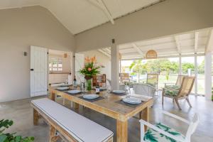 a dining room with a wooden table and chairs at Quaint 4BDR villa with pool in Grand Gaube in Grand Gaube