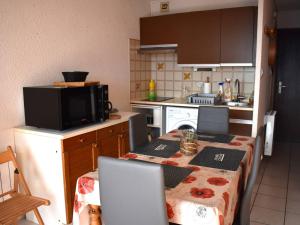 a small kitchen with a table and a microwave at Studio Font-Romeu-Odeillo-Via, 1 pièce, 4 personnes - FR-1-580-86 in Font-Romeu-Odeillo-Via