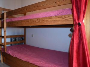 a bedroom with two bunk beds with a red curtain at Studio Font-Romeu-Odeillo-Via, 1 pièce, 4 personnes - FR-1-580-86 in Font-Romeu-Odeillo-Via