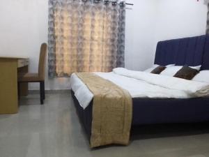 a bedroom with a large bed and a desk at St Theresa apartment Lodge in Lagos