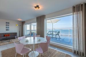 uma sala de estar com mesa e cadeiras e vista para o oceano em ROOFTOP em Oostende