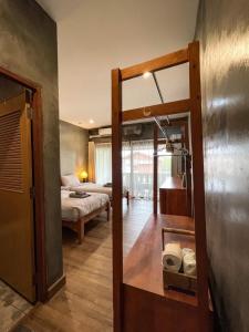 Habitación con dormitorio con cama y espejo. en BOSS HOTEL CHIANGMAl en Chiang Mai