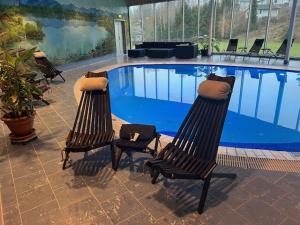 two chairs sitting in front of a swimming pool at Hindåsgården Hotel & Spa in Hindås