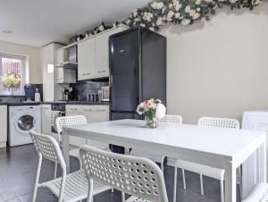 a kitchen with a white table and chairs at Large 4-bedrooms & 3 Bath Townhouse, Free Parking in Liverpool