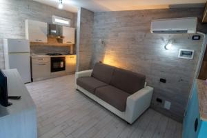 uma sala de estar com um sofá e uma cozinha em Il Posto em Pulsano