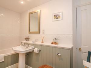 a bathroom with a sink and a mirror at Bay Tree Cottage in Kingsbridge