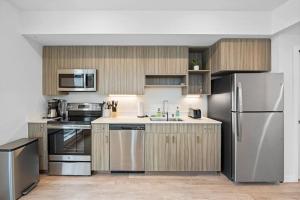 una cocina con electrodomésticos de acero inoxidable y armarios de madera en Comfy 1bd1ba In Riverside Wqueenbedgymwi-fi-dt, en Spokane