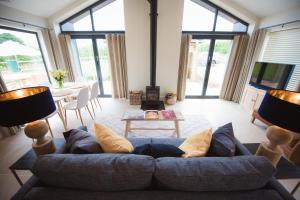 a living room with a blue couch and a table at Holly Lodge and Little Orchard in Kingsdown