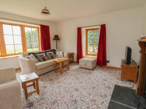a living room with a couch and a tv at The Milk House in Fortrose
