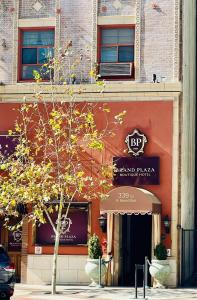 a building with a tree in front of a store at Brand Plaza Hotel in Glendale