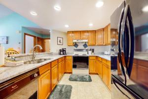 a kitchen with wooden cabinets and stainless steel appliances at Relaxing on the River in Lincoln