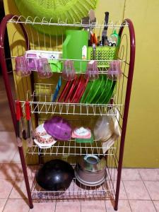 una estantería de alambre con utensilios y otros artículos de cocina en LD SWEET HOMESTAY LAHAD DATU, en Lahad Datu
