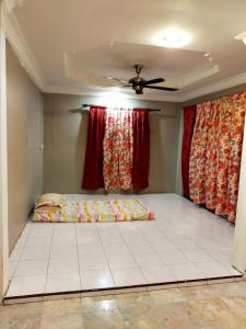 Schlafzimmer mit einem Bett und einem Deckenventilator in der Unterkunft LD SWEET HOMESTAY LAHAD DATU in Lahad Datu