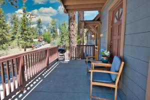 a porch of a house with two chairs and a door at Fox 'n Bear Cottages in Big Bear Lake