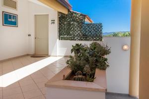 a house with a balcony with plants in a courtyard at La Terrazza sul Mare in SantʼAgata di Militello