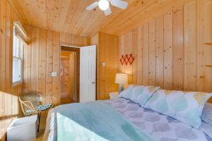 Lakefront Pelican Rapids Cabin with Boat Dock! في Dunvilla: غرفة نوم بسرير في غرفة بجدران خشبية