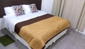Un dormitorio con una cama con almohadas. en InTown Apart Santa Cruz en Santa Cruz