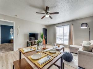 a living room with a table and a ceiling fan at 6 min to UT Southwestern_Fast Wi-fi in Dallas