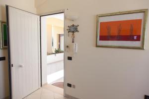 a hallway with a white door and a picture on the wall at La Terrazza sul Mare in SantʼAgata di Militello