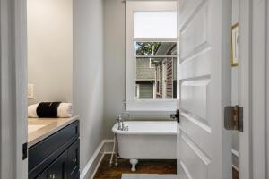 a bathroom with a bath tub and a window at Simmons Whimsical Historic Home in Wilmington +53 photos