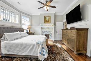 a bedroom with a bed and a flat screen tv at Simmons Whimsical Historic Home in Wilmington