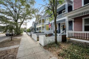 a row of houses on a street with an american flag at Simmons Whimsical Historic Home in Wilmington
