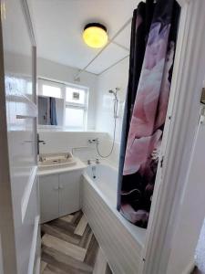 a white bathroom with a tub and a sink at 3 bedroom Flat in Hoxton London in London