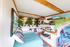 Habitación con cama y pintura en la pared en Hummingbird Hideout, en Port Orford