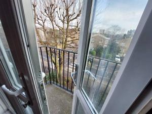 a door to a balcony with a view of a street at 3 bedroom Flat in Hoxton London in London