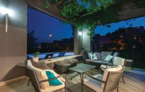 a patio with a couch and chairs and a large window at Villa Beganovic with private heated pool in Podstrana
