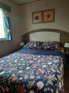 1 dormitorio con 1 cama con colcha de flores en Schier Stee, en Vlagtwedde