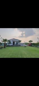 a large field with a building in the background at MB farms in Greater Noida