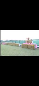 a room with a bed with pink furniture in it at MB farms in Greater Noida