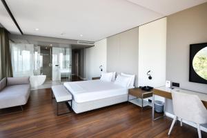 a bedroom with a white bed and a living room at Yacht Hotel in Vlorë