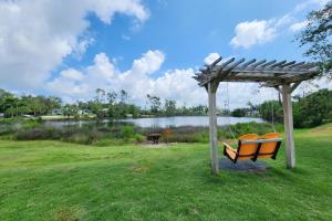 a bench under a pergola next to a lake at A Love of Leisure in Panama City