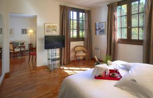 Un dormitorio con una cama y un televisor y una sala de estar. en Hotel Villa Victoria de Tigre, en Tigre 53 fotos más