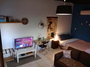 a bedroom with a bed and a tv and a couch at H&M Prive HOME MÀRGARITES RETHYMNO 115sqm in Margarítai