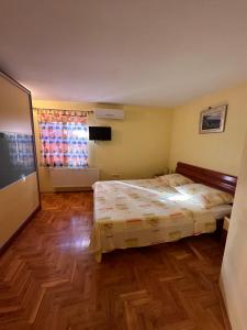 - une chambre avec un lit et du parquet dans l'établissement Apartman Lana, à Kaštela