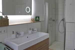 a white bathroom with a sink and a shower at Apartment Am Mittelpunkt Deutschlands in Niederdorla